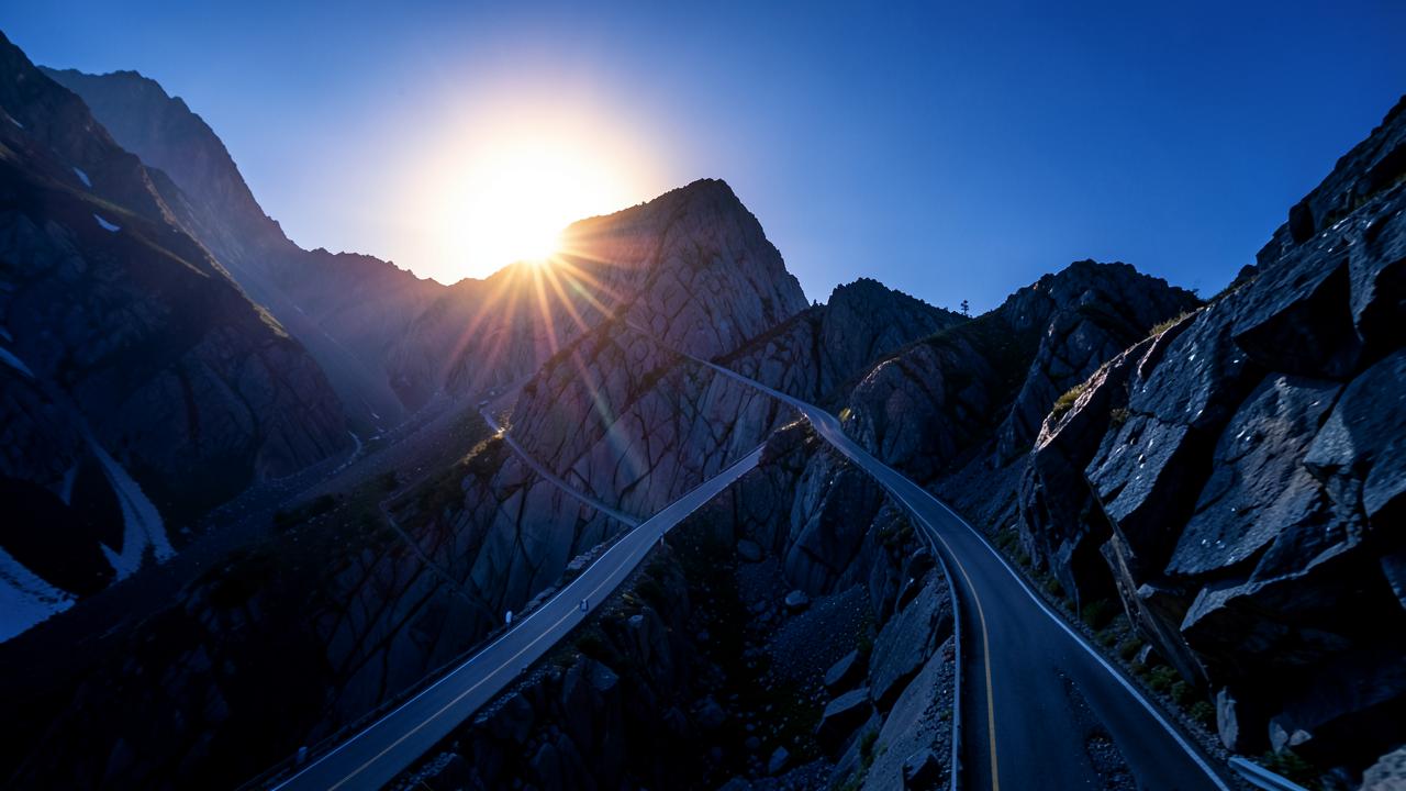 A steeply climbing road cut through rock, lit by warm light at the summit