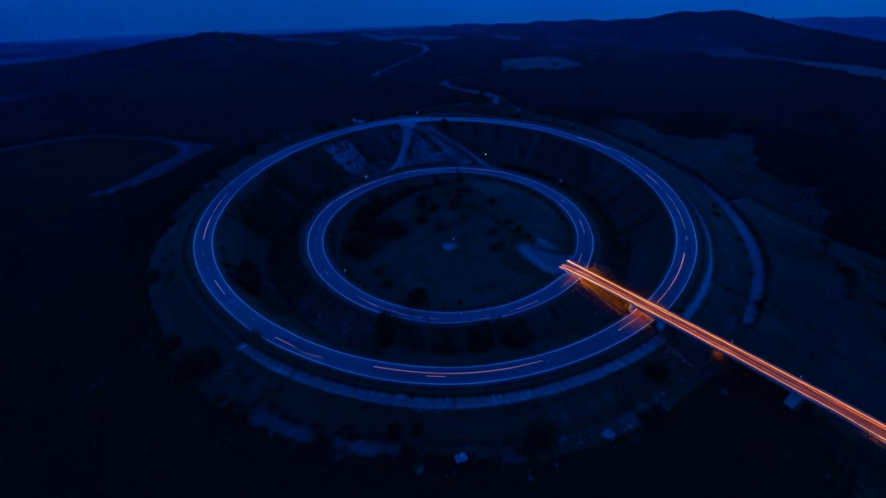 A looping circular road doubling back on itself, navy landscape with an orange exit route