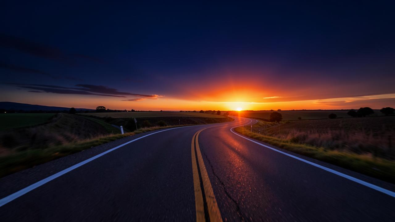 A winding road at dawn with warm orange light ahead, symbolising renewed team energy